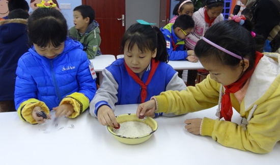 1447664393734008555.jpg 小朋友们在混合物中用磁铁找出回形针.jpg